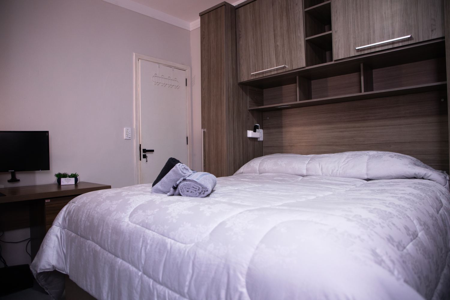 Quarto com cama de casal, TV e ar-condicionado